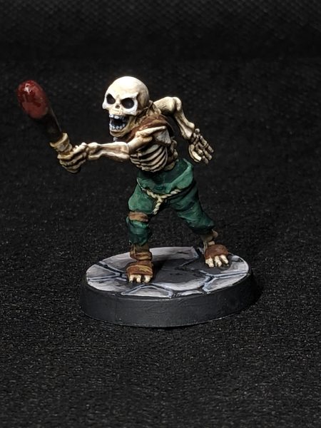 Painted skeleton miniature with a blood-red club on a stone-tile base
